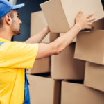 Self-storage Vs. Storage Pick-up Service: What You Need to Know 2 Delivery worker unloading cardboard boxes from a van, showcasing efficient packing and moving practices in logistics.