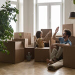 How to Move a Pool Table: A Step-by-Step Guide for New York Residents 1 Father and daughter sharing a joyful moment while surrounded by moving boxes in a bright, airy room, symbolizing family bonding during relocation.
